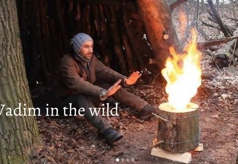 Vadim in the wild happily sitting near swedish fire torch in the forest of Ukraine.